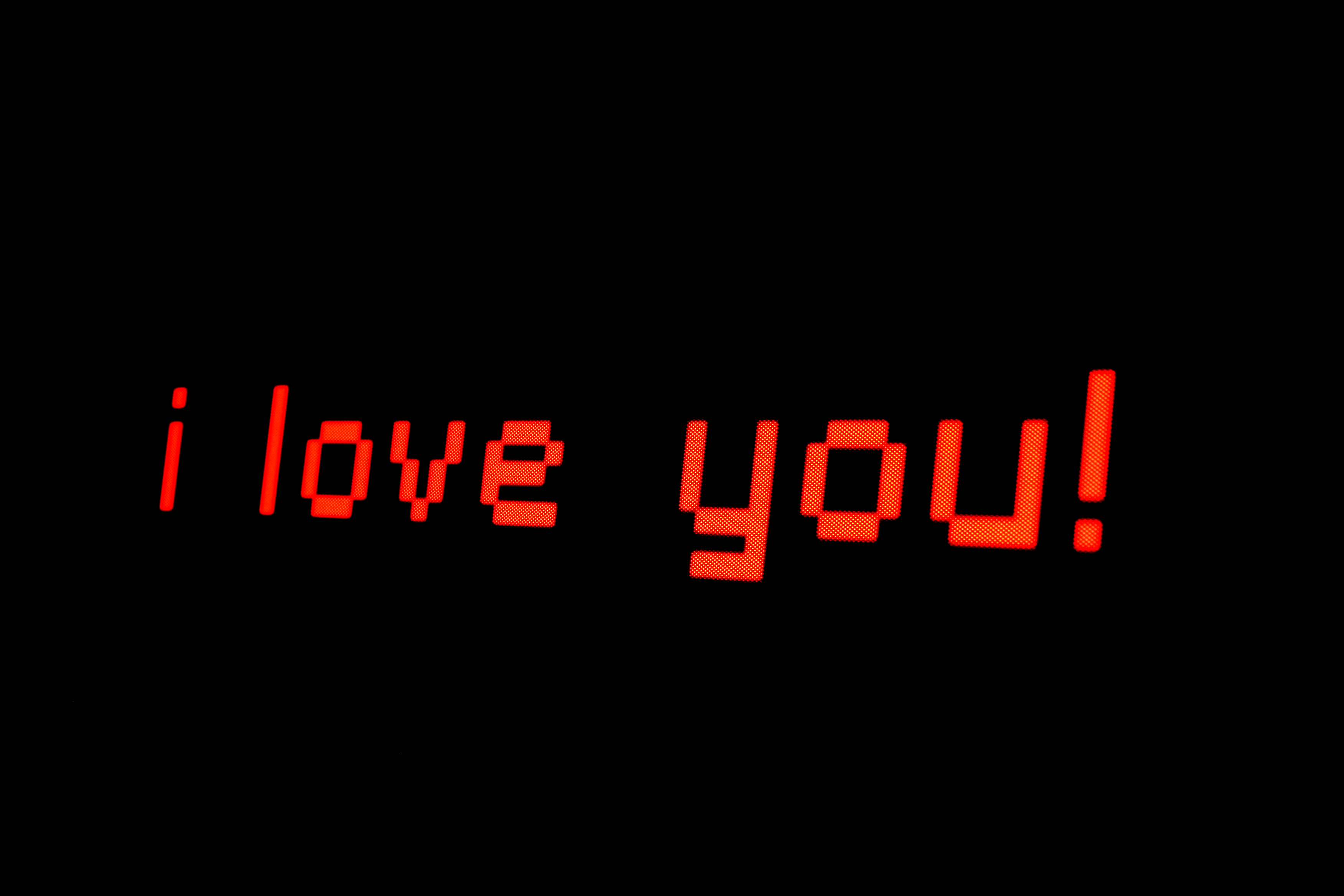 Image Description: "I love you" written in red, digital font against a black background. 