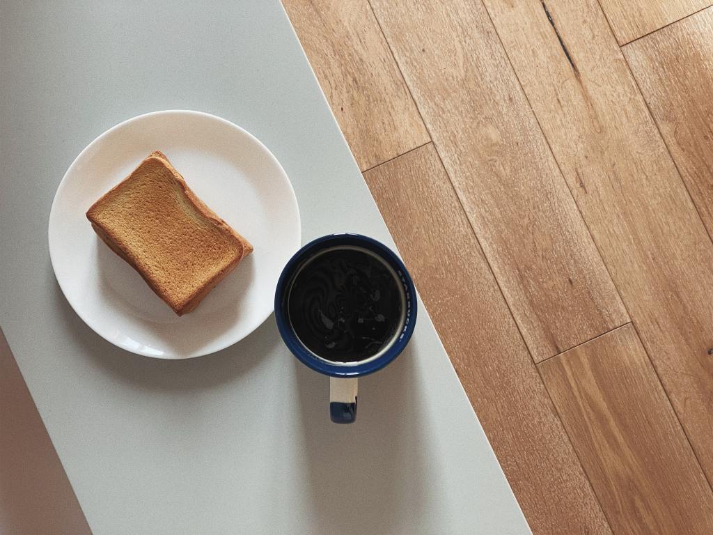 Toast on a plate next to a cup of coffee.